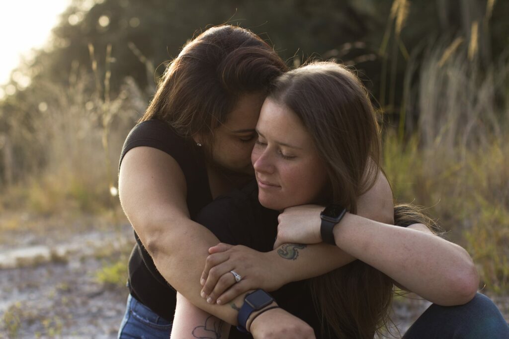 lgbtq woman hugging her fiancée at sunset in a park in orlando, captured by an engagement photographer